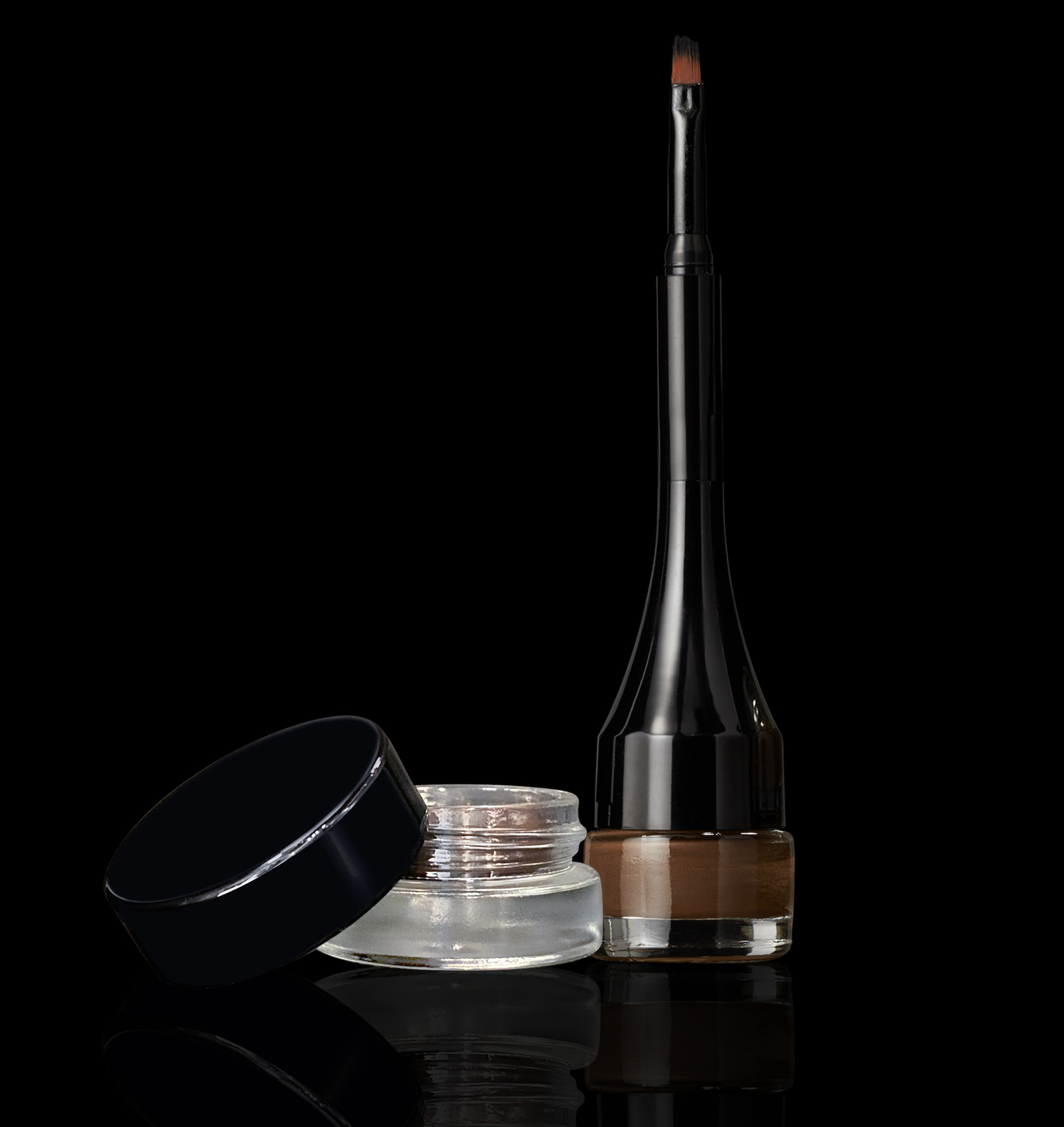 Brow Cream Liner in a glass jar alongside a pyramid shaped container with applicator